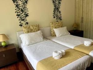 dos camas sentadas una al lado de la otra en una habitación en Two-bedroom villa with pool, en Ban Ang Thong
