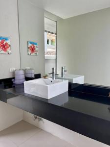 y baño con lavabo blanco y espejo. en Two-bedroom villa with pool, en Ban Ang Thong