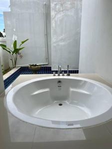y baño con bañera blanca grande. en Two-bedroom villa with pool, en Ban Ang Thong