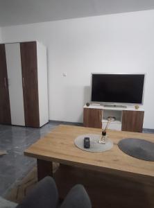 uma sala de estar com uma mesa e uma televisão em NEER em Živinice