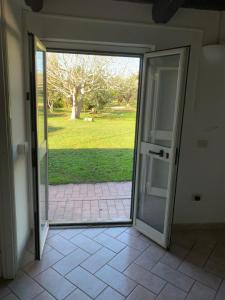 una puerta corredera de cristal abierta con vistas a un patio en Casetta degli Ulivi Maccarese, en Le Cerquete