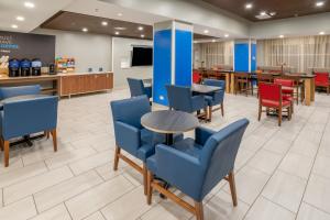 a waiting room at a hospital with blue chairs and tables at Holiday Inn Express Hotel & Suites Salisbury - Delmar, an IHG Hotel in Delmar