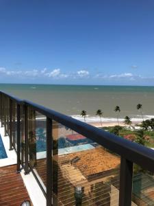 a view of the beach from a balcony at Maravilhoso local para aproveitar e descansar in Conde