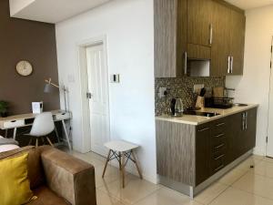 kuchnia ze zlewem i kanapą w pokoju w obiekcie Urban Awe Apartment: iTowers 21st Floor w mieście Gaborone