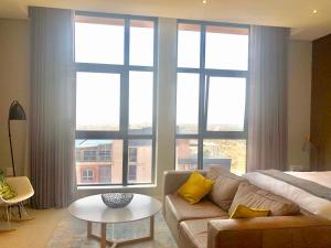 sala de estar con sofá y ventana grande en Urban Awe Apartment: iTowers 21st Floor, en Gaborone
