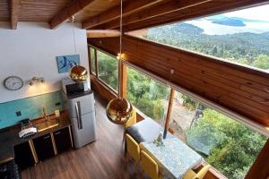 a kitchen with a large window in a house at Cabaña de montaña en Cerro Otto con increible Vista al Lago in San Carlos de Bariloche