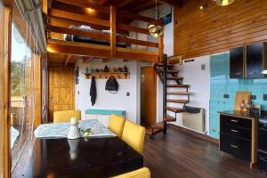 a room with a dining table and a loft bed at Cabaña de montaña en Cerro Otto con increible Vista al Lago in San Carlos de Bariloche