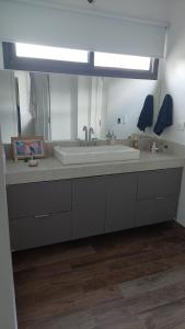 baño con lavabo grande y espejo en Casa DeCa en Luján de Cuyo