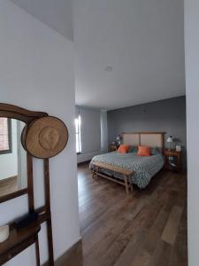 1 dormitorio con 1 cama y suelo de madera en Casa DeCa en Luján de Cuyo