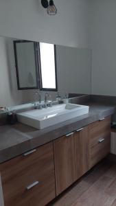 y baño con lavabo blanco y espejo. en Casa DeCa en Luján de Cuyo