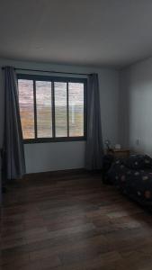 1 dormitorio con ventana grande y cama en Casa DeCa en Luján de Cuyo