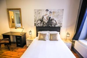 a bedroom with a bed with a bicycle painting on the wall at Le 34 Malon, T5 hypercentre chic et cosy, wifi, netflix par SOVALFI in Saint-Étienne