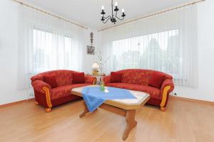 ein Wohnzimmer mit zwei roten Sofas und einem Tisch in der Unterkunft Ferienhaus Maiti in Esens