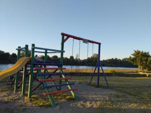 an empty playground with a slide and a swing at Casa de la Ribera Pelantaro in Valdivia