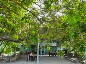 a patio with tables and chairs under a canopy at Cu Chi Boutique Farmstay in Ho Chi Minh City