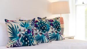 a bed with blue and white pillows on it at Jervis Shores in Callala Bay