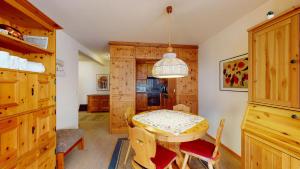 a dining room with a table and wooden cabinets at Carla 7 in Sils Maria +22 photos