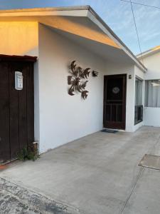 a white house with a door and a sign on it at Baja Azul in Ensenada