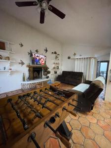 uma sala de estar com uma grande mesa de madeira com armas em Baja Azul em Ensenada