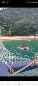 um grupo de pessoas andando em uma jangada na água em Casa em Paraty a 7 min. do Centro histórico em Paraty