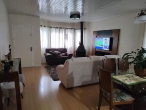 sala de estar con sofá blanco y TV en Casa Matriz Palace, en Canela