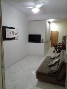 a living room with a couch and a tv at Kitnet Itapuã in Vila Velha