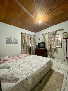 1 dormitorio con cama y techo de madera en Casa Village, en Porto Seguro