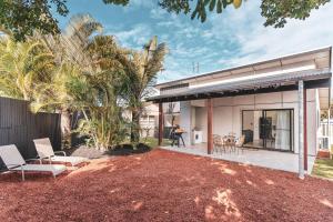a home with a patio with chairs and trees at Poplar Villa - 1 Poplar Lane in Evans Head