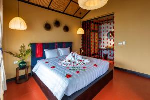 Un dormitorio con una cama grande con flores rojas. en Sapa Farmstay, en Sa Pa