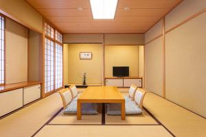 Sala de conferencias con mesa, sillas y TV en The Saihokukan Hotel en Nagano