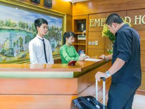 a man and a woman standing at a counter at Emerald Boutique Hotel in Hanoi