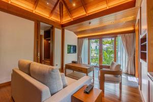 a living room with a couch and a table at The Surin Phuket in Surin Beach