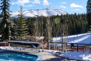 a swimming pool with a snow covered mountain in the background at Beaver Run Studio With Kitchen, Dog Friendly- 4217 in Breckenridge