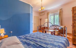 a blue bedroom with a bed and a table at Liznjan - Blue Gate Manor in Ližnjan