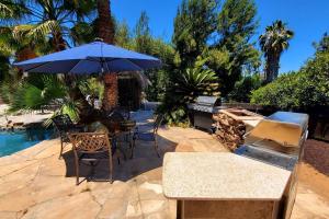 a table and chairs with an umbrella next to a pool at Special Vacation House/ Pool & Basketball Court in El Cajon