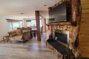 a living room with a large stone fireplace with a tv at Special Vacation House/ Pool & Basketball Court in El Cajon