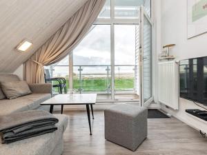 WendtorfにあるTwo-Bedroom Holiday home in Wendtorf 1のリビングルーム(ソファ、テーブル付)、窓が備わります。