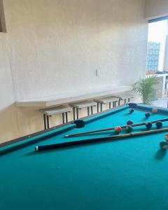 una sala de billar con mesa de billar y mesas en hotel xucum, en Campeche