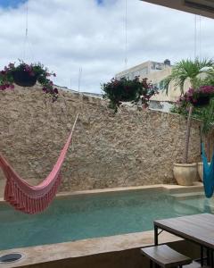 a hammock is hanging over a swimming pool at hotel xucum in Campeche