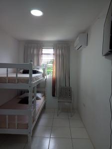 a small room with two bunk beds and a window at Pousada da Sônia in Camaragibe