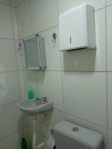 a bathroom with a sink and a toilet and a mirror at Pousada da Sônia in Camaragibe