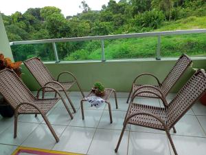 een veranda met drie stoelen en een potplant erop bij Pousada da Sônia in Camaragibe