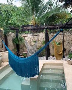 a blue hammock next to a pool of water at hotel xucum in Campeche