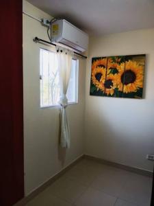 a room with a window with a curtain and a painting at Apartamento amplio, confortable aire acondicionado in Ríohacha