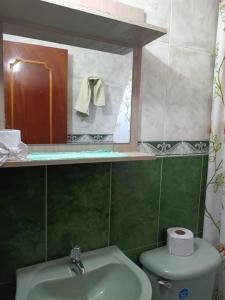 a bathroom with a sink and a toilet and a mirror at Apartamento amplio, confortable aire acondicionado in Ríohacha
