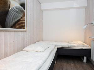 two beds in a room with a picture on the wall at Two-Bedroom Holiday home in Wendtorf 5 in Wendtorf