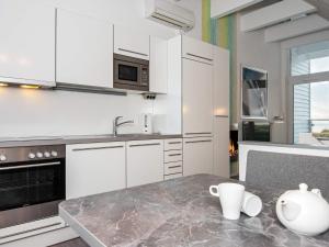 eine Küche mit weißen Schränken und einer Marmoroberfläche in der Unterkunft Two-Bedroom Holiday home in Wendtorf 5 in Wendtorf
