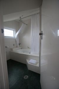 ein weißes Bad mit einer Badewanne und einer Dusche in der Unterkunft Mornington Bed & Breakfast in Mornington