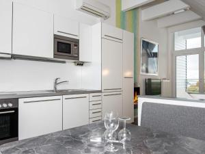 una cocina con armarios blancos y una mesa con copas de vino. en 6 person holiday home in Wendtorf, en Wendtorf