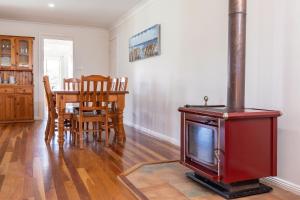 a living room with a red stove and a table at 36 Churchill in Forster